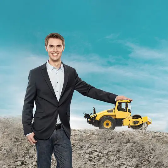 Eine Grafik zeigt einen Mann auf einer Baustelle, der die Hand auf ein gelbes Baufahrzeug legt.