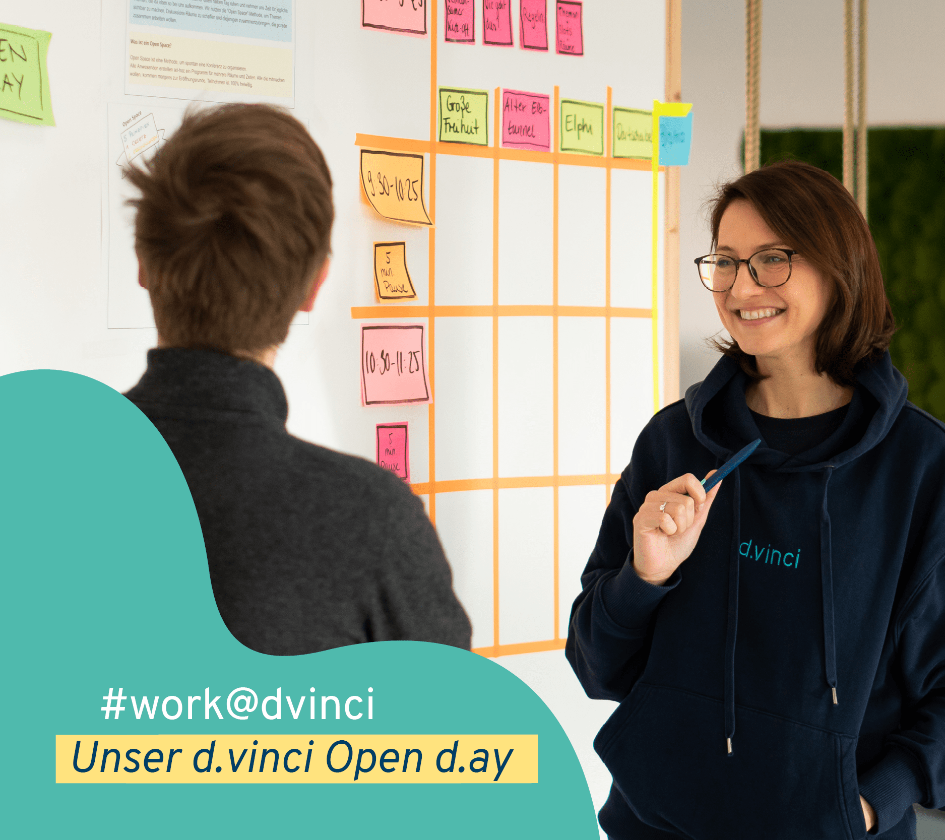 Zwei Personen stehen vor einer Wand mit Post-Its